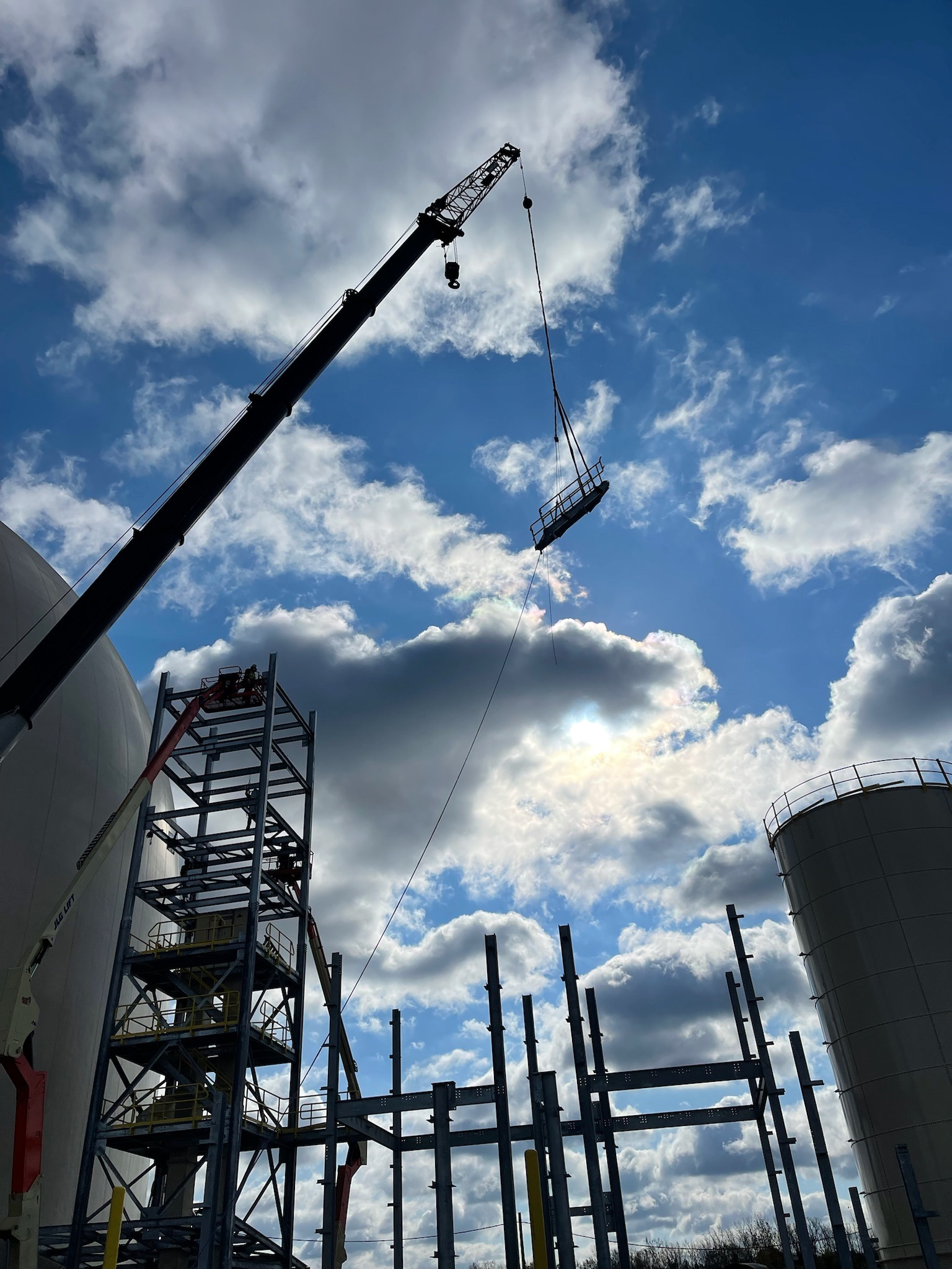 Industrial construction showing a crane lifting a beam into the air